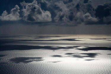 Clouds cast their shadows on the Gulf of Mexico clouds,shadows,sea,gulf,marine,seascape,oil platforms,grey,horizon