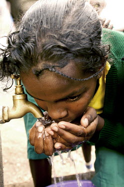 Conservation Issues: school children drinking from tap Africa,conservation,conservation issue,conservation issues,water,clean water,drinking water,collect,collecting,urban,village,people,tap,shallow focus,drink,drinking,thirst,face,close-up,close up,hands