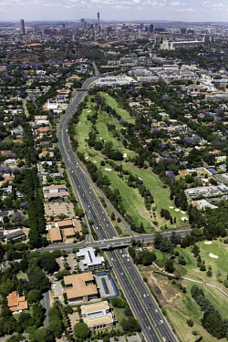 Aerial view of the main highway travelling through to the city centre in the distance - Johannesburg, South Africa Aerial,Landscape,City,Suburbs,Road,Buildings,Houses,Neighbourhood,Trees,Rooftops,Settlement,Tree-lined,Colourful,Purple,Colour,City centre,Skyline,Highway,Main road,Golf course