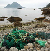 Marine litter of ropes and fishing nets washed up on beach nets,beach,coast,norge,rope,litter,environment,environmental issues,marine debris,plastic waste,marine litter,rocky beach,green rope,colourful,stones,bolders
