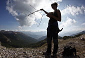 Researcher collecting field data for an Apennine brown bear project conservation,endemic,subspecies,Europe,Lazio e Molise,Parco Nazionale d'Abruzzo,large mammals project,La Sapienza University,Rome,field data collection,telemetry,radio tracking,clouds,sky,mountainside