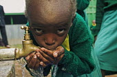 Conservation Issues: school children drinking from tap Africa,conservation,conservation issue,conservation issues,water,clean water,drinking water,collect,collecting,urban,village,people,tap,shallow focus,drink,drinking,thirst,face,eyes,close-up,close up,