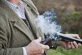 Detail photograph of well dressed man holding a shotgun during a pheasant shoot. hunting,hunt,gun,guns,violence,violent,skill,enjoyment,recreational sport