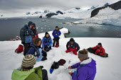 Tourists gathered around a glacierologist sharing his knowledge while gathering samples for his studies iceberg,ice,snow,cold,snowy,cold weather,winter,Christmas,freezing,frozen,landscape,habitat,climate change,global warming,climatology,climate science