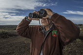 A man tracking Iberian lynx, scoping the landscape researcher,research,tracking,tracker,binoculars,looking,waiting,conservation,science,field work,lynx,Iberian lynx,humans,people