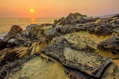 A rocky coastline at sunset Sky,environment,ecosystem,Habitat,Sea,seas,Orange background,stones,gravelly,Rock,pebble,stone,stony,rocky,gravel,pebbles,rocks,Evening,nightfall,sunsets,dusk,sun set,Sunset,Morning,Dawn,Sunset sky,Da