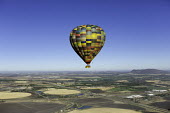 Hot air balloon rises up above farmland - South Africa Hot-air balloon,Lake,Flying,Ride,Calm,Blue sky,Clear sky,Mountains,Entertainment,Activity,Excursion,View,Colourful,High up,Farmland