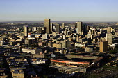 Johannesburg skyline in the sun - Johannesburg, South Africa Aerial,Skyline,Landscape,City,City centre,Road,Clear sky,Blue sky,Highrise,Buildings,Sun