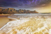 The seashore backed by the Kogelberg Mountains with dramatic clouds overhead - South Africa Beauty in nature,Stones,Pebbles,Coastal,Coast,Sea,Ocean,Sunset,Mountains,Background,Long exposure,Dramatic sky,Cloud formation,Waves,Landscape,Beach,Sand,Tranquil,Nobody