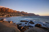 View of Camps Bay at sunset with the view of the Twelve Apostles mountain range - Cape Town, South Africa Aerial,Coastal,Town,Beach,Sand,Mountain,Cliff,Settlement,Civilisation,Ocean,Sea,Bluesky,Rock formation,Sunset